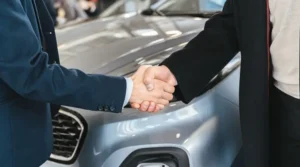 Poignée de mains entre concessionnaire et conducteur qui achète avec aide financière voiture électrique de Québec