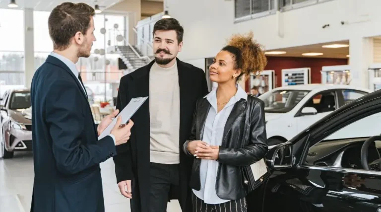 Couple qui achète une voiture électrique chez un concessionnaire avec aide financière de Québec
